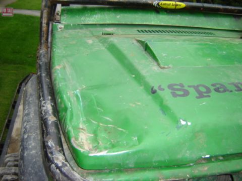 1992 Ford Bronco - A green off-road vehicle's damaged hood shows signs of wear and tear.