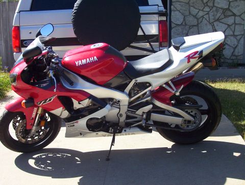 1995 Ford Bronco - A red and white Yamaha R1 motorcycle is parked in front of a Ford Bronco, with a Supermotors.net watermark visible.