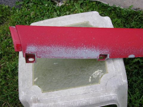 1994 Ford Probe - Red plastic car door edge trim piece with primer showing through chipped paint.
