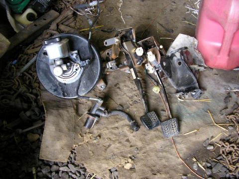 1994 Ford Probe - Brake booster and pedal assembly, including clutch pedal, laid out on the ground.