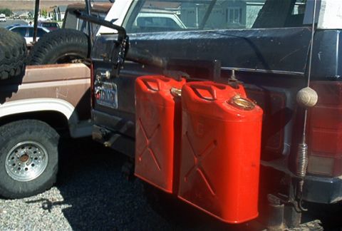 1986 Ford Bronco - Rear view of a 1986 Ford Bronco equipped with two red jerry cans and a spare tire.