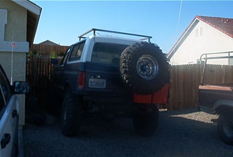 1986 Ford Bronco - Rear view of a 1986 Ford Bronco, showing its spare tire mount and roof rack.