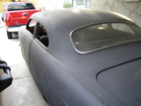 1968 Ford Mustang - A gray coupe is shown from the rear quarter angle, with a red pickup truck visible in the background.