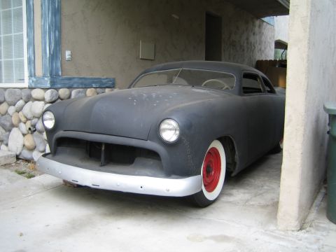 1968 Ford Mustang - Matte black hot rod coupe with red wheels and whitewall tires, likely a 1949 Ford.