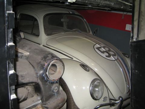 1968 Ford Mustang - A white Volkswagen Beetle, often recognized as Herbie, is parked indoors.
