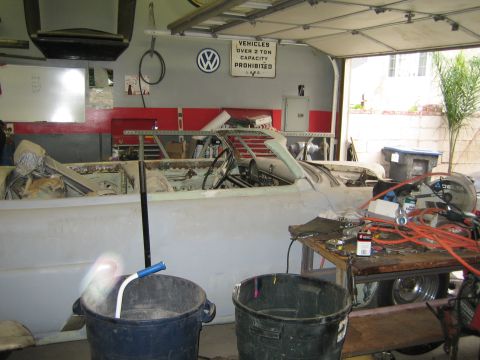 1968 Ford Mustang - A car in a state of disrepair is visible inside a garage, with tools and equipment scattered around.