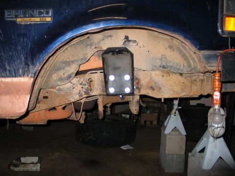 1995 Ford Bronco - Close-up view of the rear axle and suspension of a blue 1995 Ford Bronco, showing modifications and added lights.