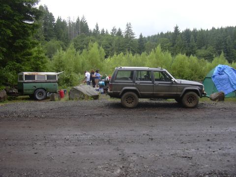 1991 Ford Bronco - A Jeep Cherokee XJ is parked at a campsite with a trailer and tent set up.