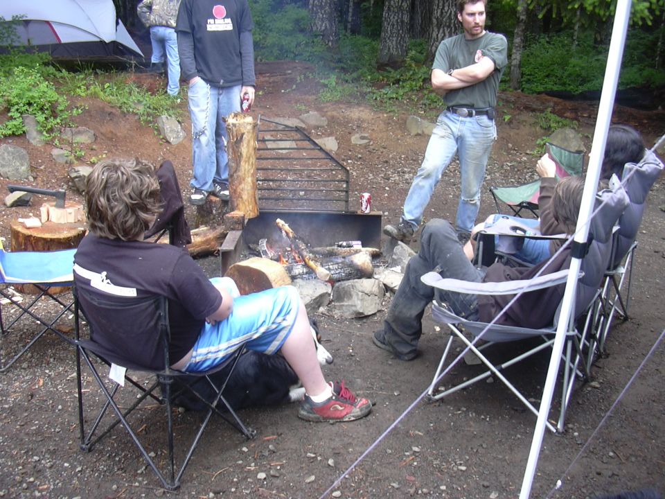 Campfire scene with people sitting in chairs