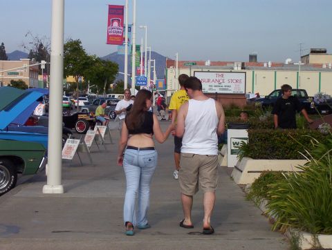 1995 Ford Bronco - Attendees stroll through a car show event with various vehicles on display.