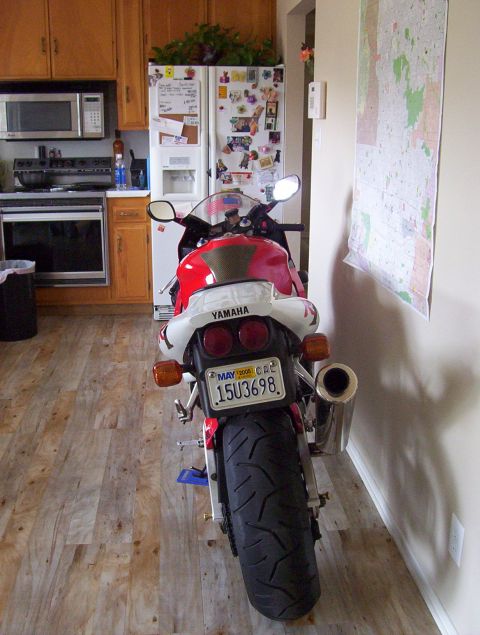 1995 Ford Bronco - Motorcycle parked indoors, showing its rear end and license plate.
