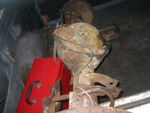 1989 Ford Bronco - A rusty differential housing is visible inside a vehicle, alongside a red toolbox.