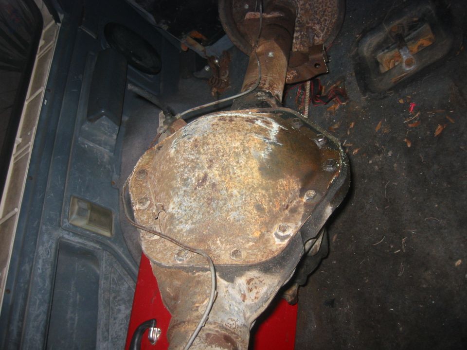 Rear differential assembly, rusty, inside vehicle cargo area