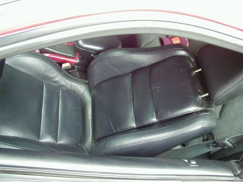 1994 Ford Probe - Interior view of black leather car seats, with visible seatbelt and part of the center console.
