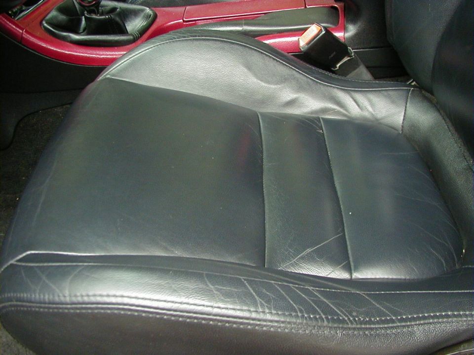 Black leather driver's seat with red trim around the center console and gear shifter