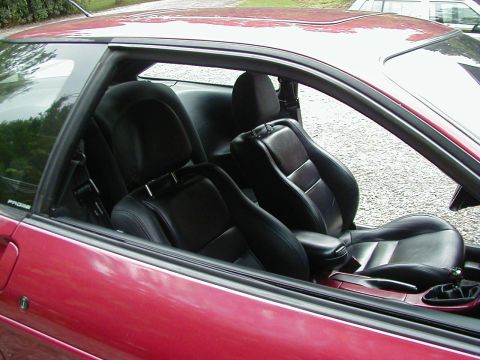 1994 Ford Probe - Interior view of a red 1994 Ford Probe, its black leather seats and manual transmission.