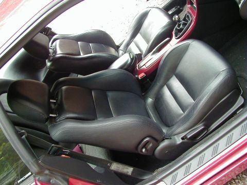 1994 Ford Probe - Interior view of a car, black leather seats and a center console. A 'PROBE' badge is visible.