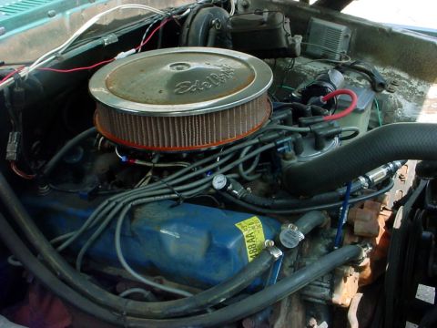 1973 Ford Ranchero - The engine bay shows a V8 motor with aftermarket parts like an Edelbrock air cleaner and blue valve covers.