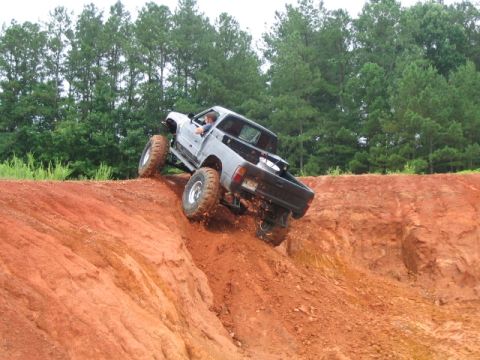 1986 Ford F-150 - Pickup truck navigating challenging off-road terrain on a sunny day.
