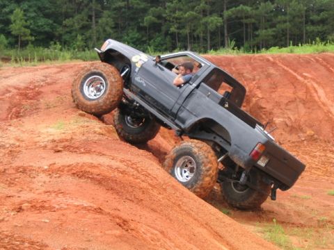 1986 Ford F-150 - This truck is tackling a challenging off-road course with steep inclines and loose dirt.