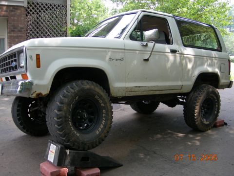 1984 Ford Bronco II - This lifted 1984 Ford Bronco II is shown in a three-quarter front view, with its large tires resting on blocks.