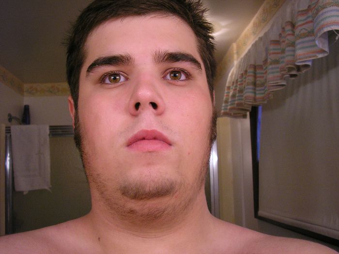 Man's face in close-up, bathroom background