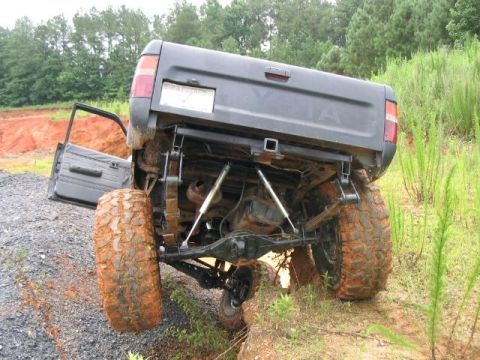 1986 Ford F-150 - This Toyota pickup truck is stuck off-road with its driver's door open and suspension heavily flexed.