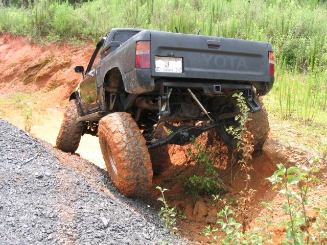 1989 Toyota pickup truck with large tires climbing a dirt hill