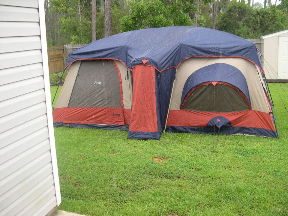 Blue and red tent with Jeep logos on a grassy lawn