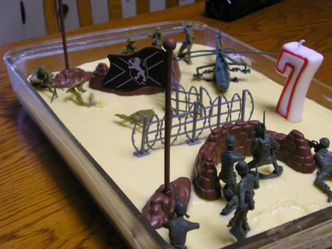 1990 Ford Probe - A cake decorated with toy soldiers, a helicopter, and a flag, a prominent number 7 candle.