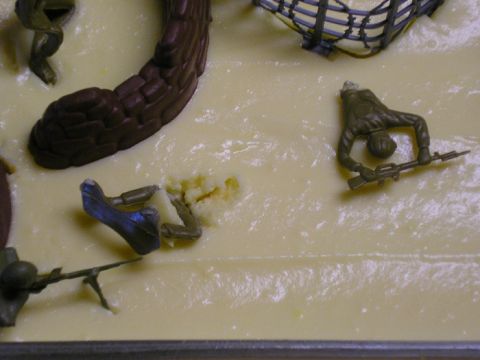 1990 Ford Probe - A diorama scene depicts toy soldiers in various poses, some appearing damaged, on a light yellow base.