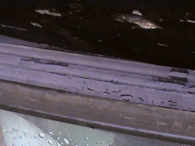 close-up of worn weather stripping on a vehicle's window frame