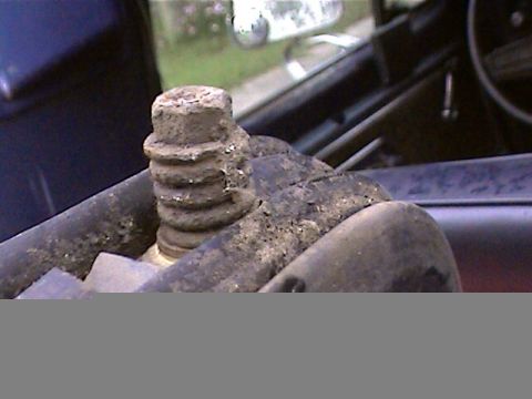 1978 Ford Bronco - A close-up view shows a heavily corroded bolt with a ribbed shaft, likely a component from a vehicle's undercarriage.