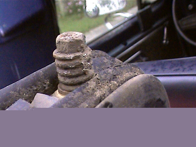 Close-up of a heavily rusted bolt with ribbed texture