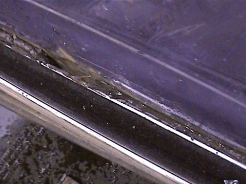 1978 Ford Bronco - This is a close-up view of a vehicle's door seal, showing wear and debris.