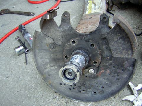 1995 Ford Bronco - Front axle knuckle with the hub, rotor and caliper removed, showing the splined stub shaft, wheel bearing race and five studs behind the pe…