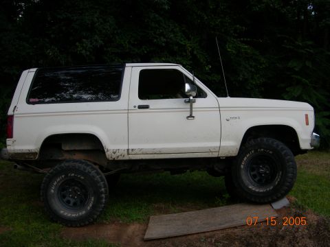 1984 Ford Bronco II - Side view of a white 1984 Ford Bronco II lifted with off-road tires.