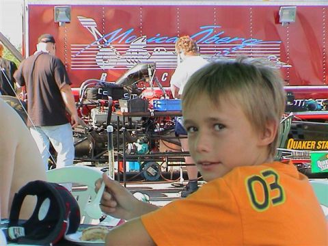 1979 Ford Bronco - Dominik eating birthday cake with a top fuel dragster behind him