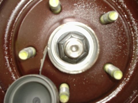 2000 Ford Taurus - This image shows a close-up view of a vehicle's wheel hub, including lug nuts and a detached dust cap.