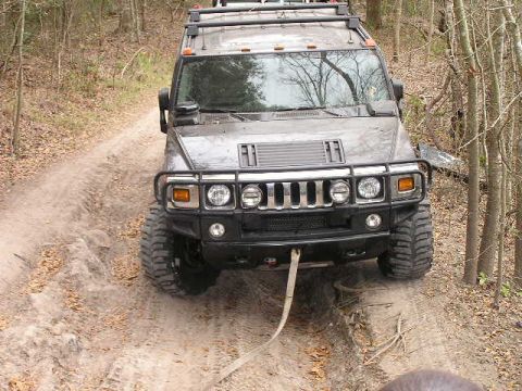 1989 Ford Bronco - Hummer H2 navigates a challenging off-road trail, demonstrating its capability on uneven terrain.