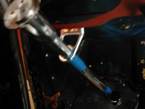 1978 Ford Bronco - The interior of a vehicle shows a chrome shifter with a blue grip, mounted on the floor.