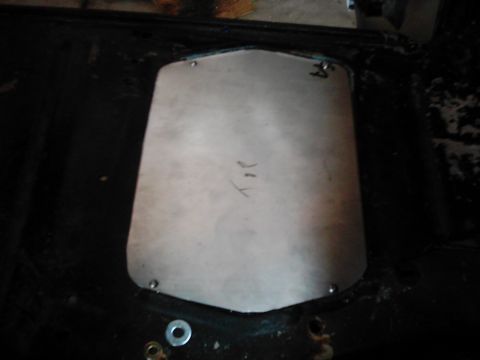 1978 Ford Bronco - A metal plate is installed in the vehicle's floor, showing some handwritten marks and screw fasteners.