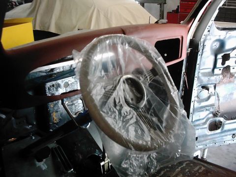 1978 Ford Bronco - The interior of a vehicle undergoing restoration, showing a steering wheel covered in protective plastic.