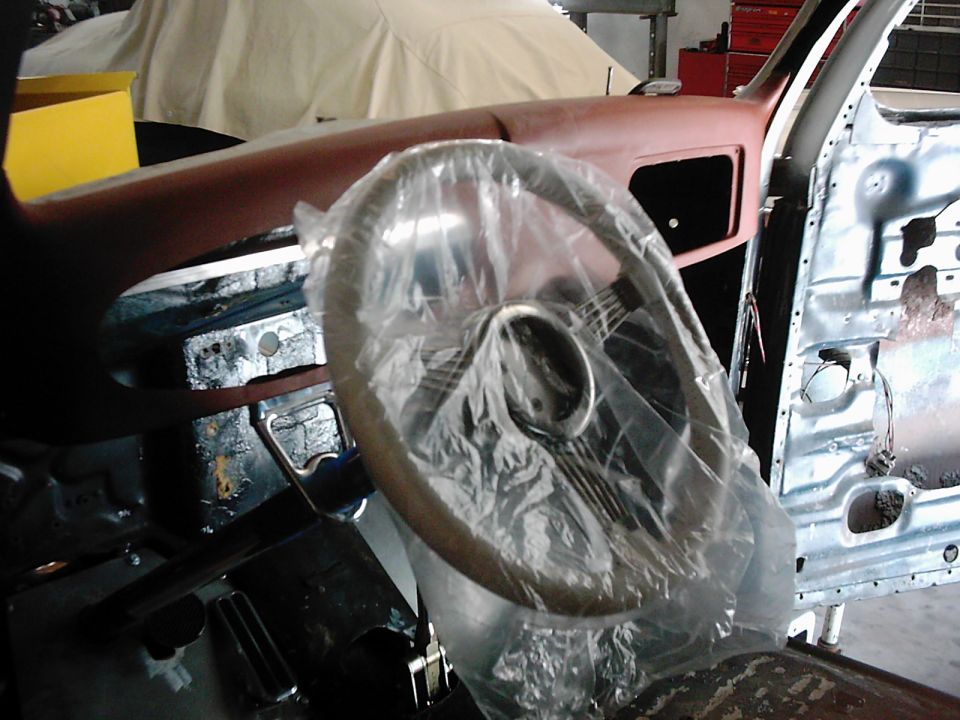Steering wheel covered in plastic inside a disassembled car interior