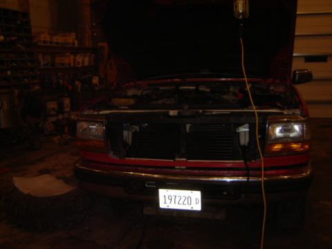 1992 Ford Bronco - A red truck is parked in a garage with its hood open, revealing the engine compartment. A license plate reads 197220 D.
