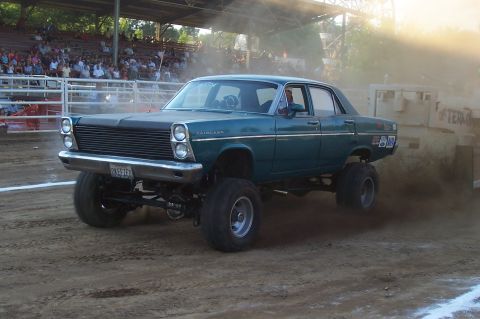 1994 Ford F-150 - This modified sedan, identified by its 'Fairlane' badge, is participating in an event, kicking up dust.