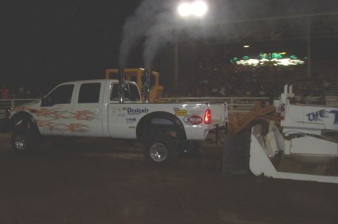 1994 Ford F-150 - Modified pickup truck with flame decals and dual exhaust stacks at an event.