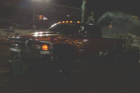 1994 Ford F-150 - A modified Dodge Ram pickup truck emits dark smoke while driving at night.