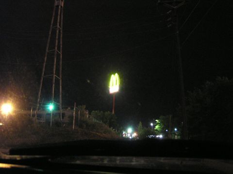 1993 Ford Taurus - The iconic golden arches of McDonald's glow brightly against the dark night sky, viewed from the perspective of a vehicle's dashboard.