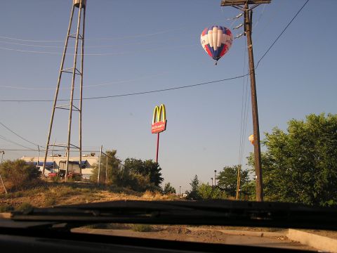 1993 Ford Taurus - A hot air balloon drifts in the sky above a McDonald's restaurant and a tall water tower.